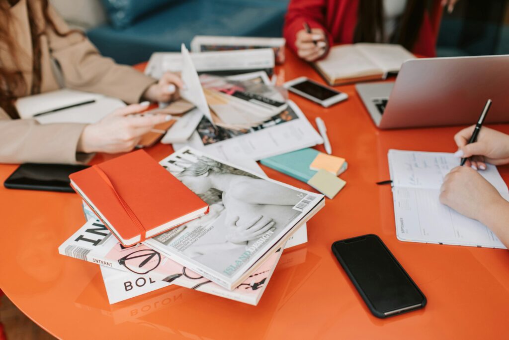 Professional team collaborating with documents, laptops, and notebooks in a modern office setting.